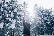 Portrait of young woman doing exercise in snowy forest. — Stock Photo