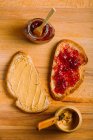 Directly above view of peanut butter and jelly sandwiches and ingredients on table — Stock Photo