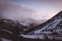 Pittoresca vista sulle bellissime montagne innevate e la piccola casa nella giornata invernale . — Foto stock