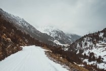 Estrada rural em montanhas cobertas de neve . — Fotografia de Stock