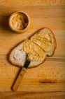 Прямо над обзором приготовления бутерброда с арахисовым маслом на столе — стоковое фото