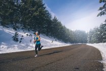 Jovem mulher em forma correndo na área nevada . — Fotografia de Stock