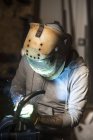 Portrait de travailleur dans le tuyau de soudage masque à l'atelier — Photo de stock