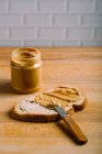 Закрыть вид на приготовление бутерброда с арахисовым маслом за столом — стоковое фото