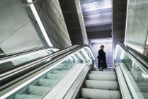 Low angle view of man posing near moving stairs at mall — Stock Photo
