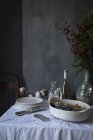 Natureza morta da mesa com pilha de pratos e tigela com peixe cozido — Fotografia de Stock