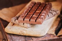 Still life of chocolate bars in cutting board — Stock Photo