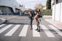 Group of friends at zebra crossing at street scene — Stock Photo