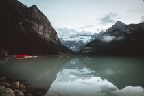Tranquillo vista sul tranquillo lago tra montagne innevate . — Foto stock