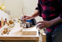 Mittelteil des Tischlers poliert Stück Holz in der Werkstatt — Stockfoto
