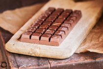 Close up view of dark chocolate bar in cutting board — Stock Photo