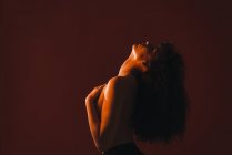 Topless curly woman posing on red background — Stock Photo
