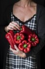 Midsection de mulher segurando belas pimentas vermelhas frescas — Fotografia de Stock