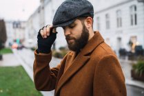 Elegante uomo in avena vintage toccare cappello e guardando verso il basso — Foto stock