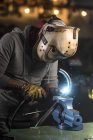 Portrait of mechanic welding pipe at workshop — Stock Photo