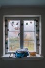 Decorated window with condensation and pile of towels on sill. — Stock Photo
