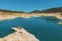 Blue lake in mountains in cloudless sunny day. — Stock Photo