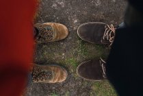 Looking down view of legs in boots standing on ground. — Stock Photo