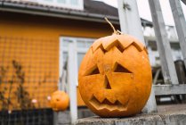 Close up view of Halloween jack-o-lantern on fence at yard — Stock Photo