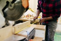 Geschnittener Tischler nimmt Maß in Stück Holz — Stockfoto