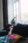 Вид сбоку на человека, лежащего дома и разговаривающего по телефону — стоковое фото