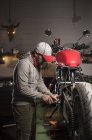Professioneller Mechaniker, der in einer Motorradwerkstatt arbeitet — Stockfoto