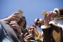 Вид знизу друзів на вулиці зі смартфоном — стокове фото