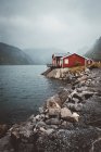 Red wooden houses at mountain lake shore — Stock Photo