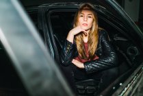 Young woman getting out of car and looking at camera. — Stock Photo