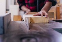 Schreiner schneidet Stück Holz mit Kreissäge — Stockfoto