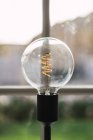 Close up view of lit vintage light bulb in lamp by window. — Stock Photo
