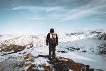 Rückansicht des Touristen posiert mit Rucksack vor dem Hintergrund der Berglandschaft — Stockfoto