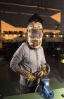 Portrait of mechanic in welding mask posing at workbench at workshop — Stock Photo