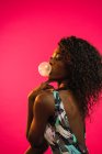 Attractive black woman blowing gum bubble — Stock Photo