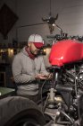 Porträt eines Mechanikers, der in einer Motorradwerkstatt arbeitet — Stockfoto