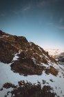Fernsicht von Touristen, die auf malerischem, schneebedecktem Berghang vor dem Hintergrund idyllischer Wolkenkratzer stehen — Stockfoto