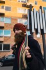 Vista lateral do homem barbudo ajustando lenço na rua — Fotografia de Stock