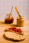 Close up view peanut butter and jelly sandwiches on background of jars — Stock Photo
