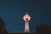 Вид знизу до освітленої вежі над нічним небом на фоні — стокове фото