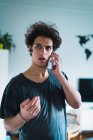 Portrait of man talking on phone at home — Stock Photo