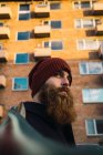 Retrato de hombre barbudo con sombrero mirando hacia la calle - foto de stock