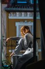 Seitenansicht der brünetten Frau posiert auf dem Balkon — Stockfoto