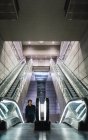 Retrato del hombre de pie sobre escaleras móviles en el centro comercial - foto de stock