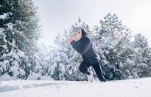 Sportliche Frau läuft rasant in verschneitem Gelände. — Stockfoto