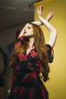 Donna rossa che balla con le braccia alzate in studio — Foto stock