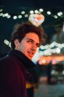 Портрет веселого человека на освещенной улице ночью — стоковое фото