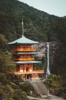 Vista para pagode asiático tradicional e bela cachoeira na floresta . — Fotografia de Stock