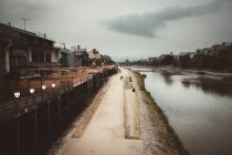 Вид на дорогу по сільській вулиці з традиційними будинками і річкою . — стокове фото