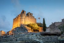Vista ad angolo basso del castello illuminato di Calafell al tramonto — Foto stock