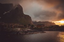 Petites maisons de village au lac de montagne au coucher du soleil crépuscule — Photo de stock
